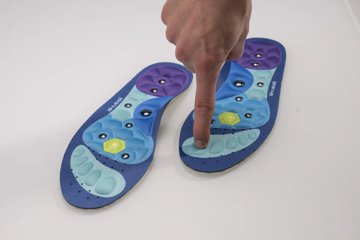 Finger pressing the textured forefoot zone of an Akusoli insole