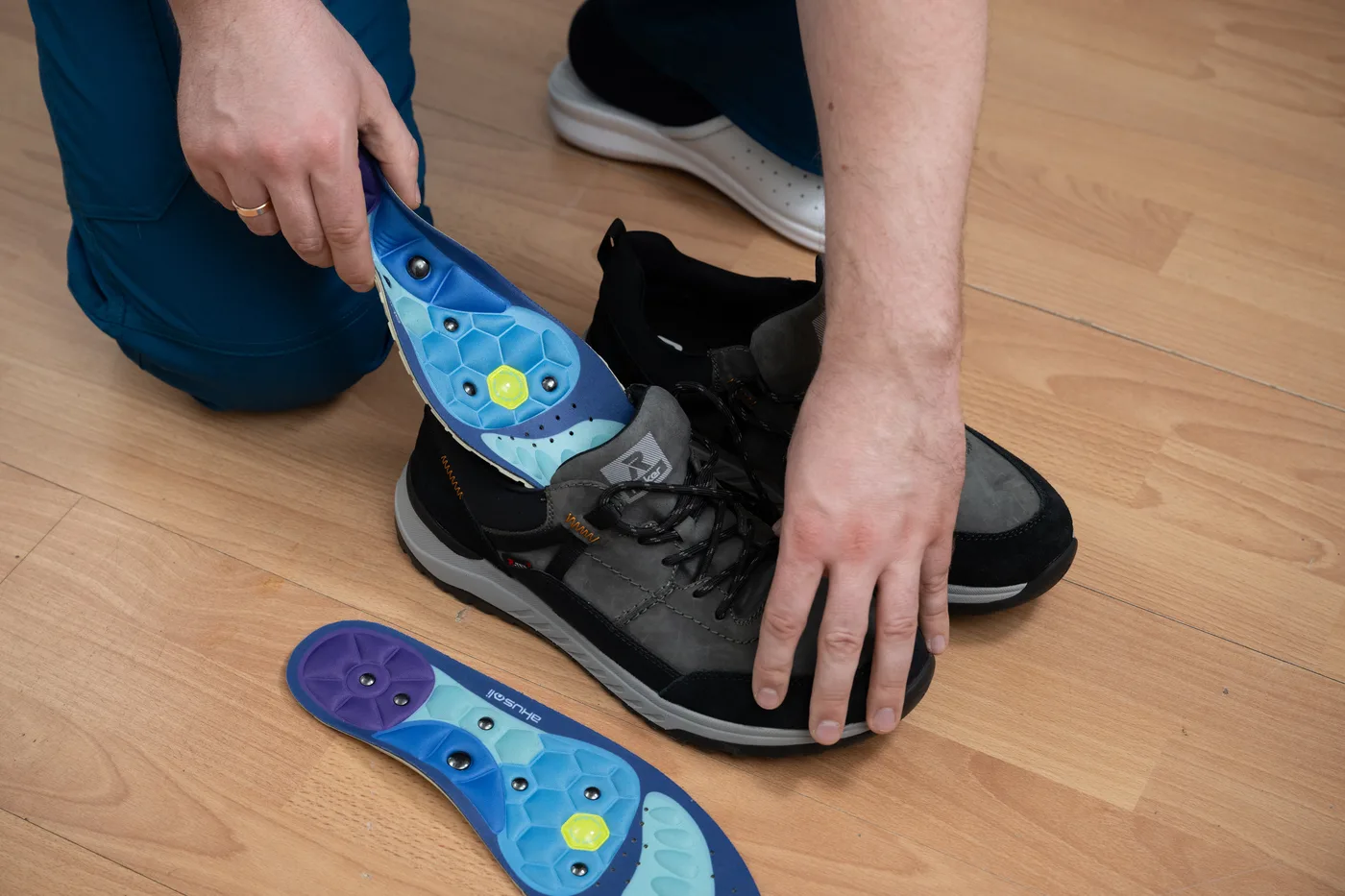 Akusoli insole being placed into a sturdy work shoe