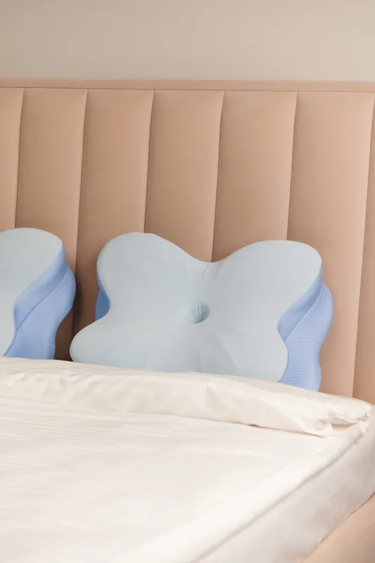 Contoured pillows arranged on a neutral bed